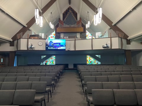 Gardena Valley Baptist Church sanctuary with installed projectors and a balcony display