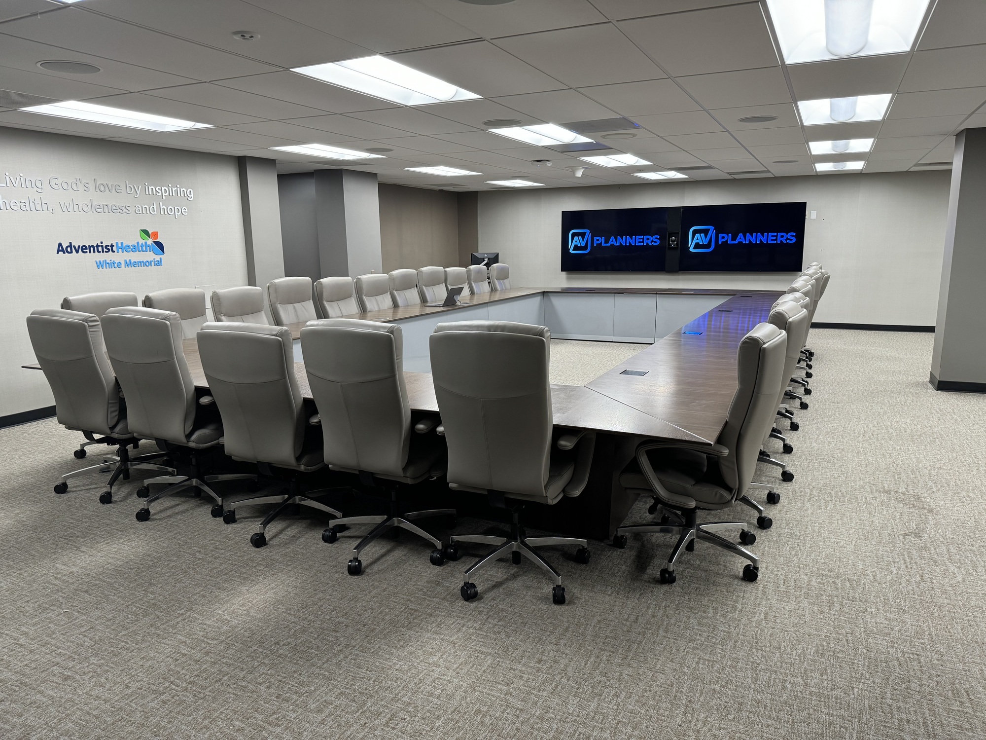 Adventist Health White Memorial conference room with dual displays and tabletop microphones