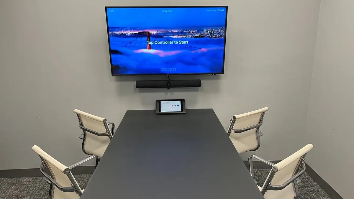 Huddle room with a Zoom display, video conferencing bar, and tabletop touch controller
