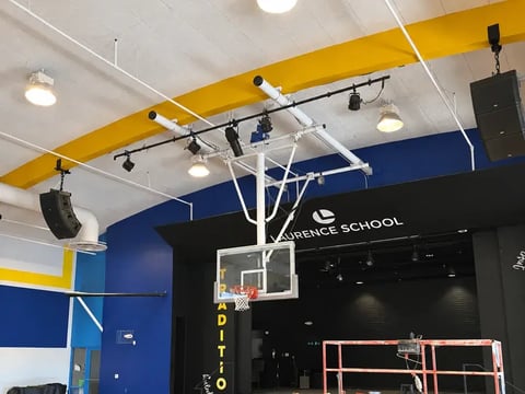Suspended loudspeakers above the gymnasium stage at Laurence School