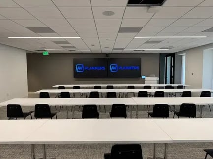 Training room with dual displays and classroom seating installed by AV Planners