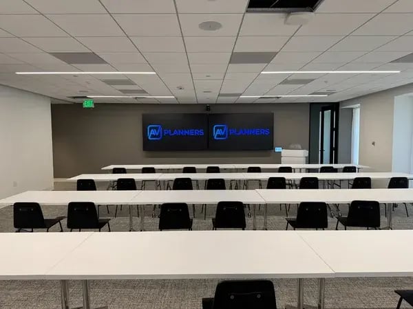 Training room with dual displays and classroom seating installed by AV Planners