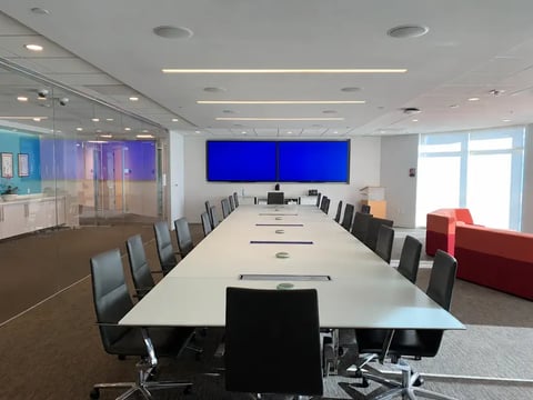 Law firm conference room with dual displays and tabletop microphones