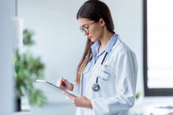 female-doctor-using-her-digital-tablet-while-stand-3AFJ8BH-2-600x400