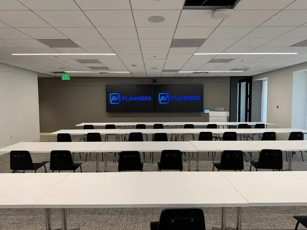 Training room with dual displays and classroom seating installed by AV Planners